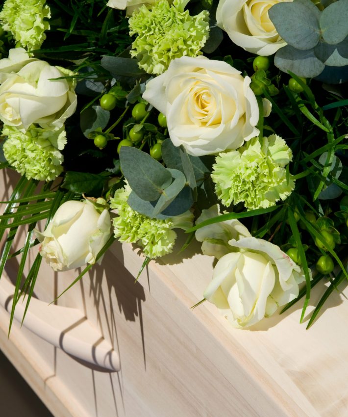 A,Coffin,With,A,Flower,Arrangement,In,A,Morgue